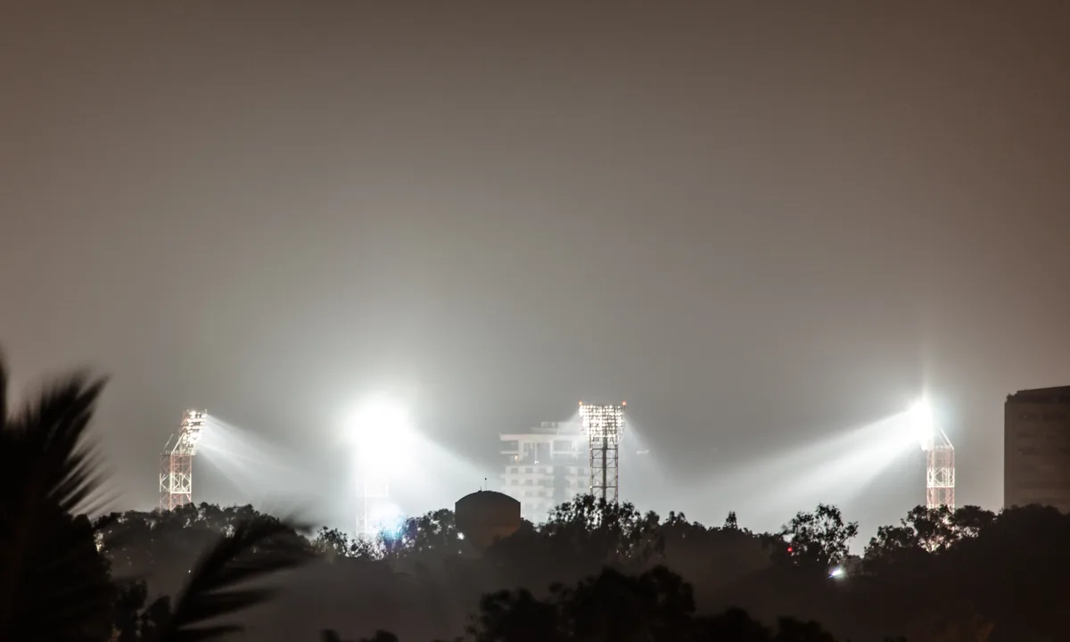 Archival Chinnaswamy Stadium floodlights beyond trees