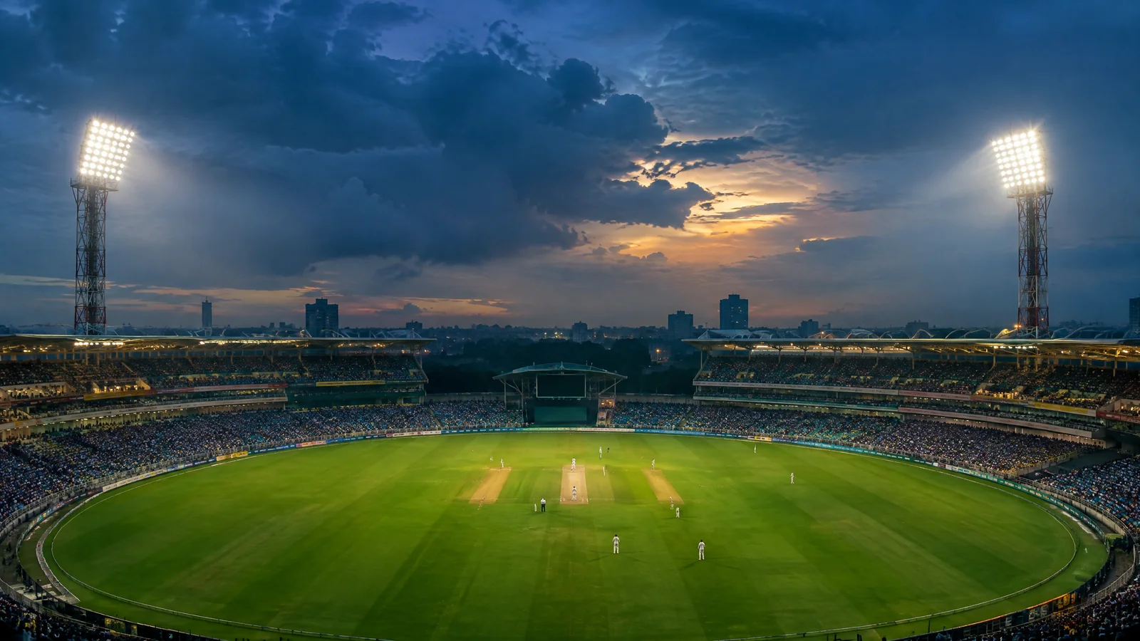 Editorial view of a floodlit Kolkata cricket stadium under monsoon clouds
