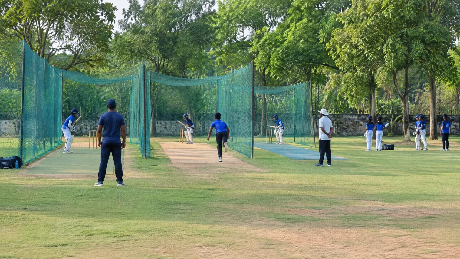 Young cricketers training in practice nets at a Tirunelveli academy centre